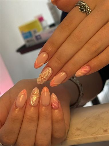 Peach almond nails with gold flower art.